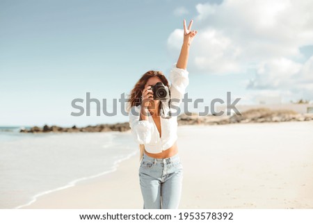 Beautiful woman taking pictures with a professional camera while walking at the beach - Young filipinos girl enjoying her summer vacation at the ocean