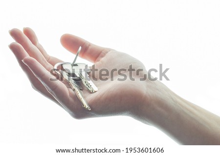 Woman hand holds a key isolated on a white background.