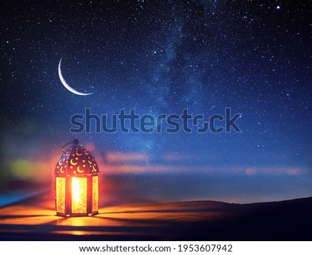 Ornamental Arabic lantern with burning candle glowing at night. Festive greeting card, invitation for Muslim holy month Ramadan Kareem. Royalty-Free Stock Photo #1953607942