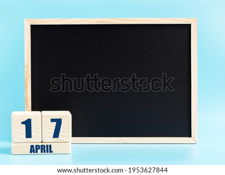 April 17th. Day 17 of month, Cube calendar with date, empty frame on light blue background. Place for your text. Spring month, day of the year concept.
