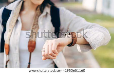 Close up hand woman people wear smart watch checking time and health information at outdoor on day. Modern lifestyle with technology gadget concept.