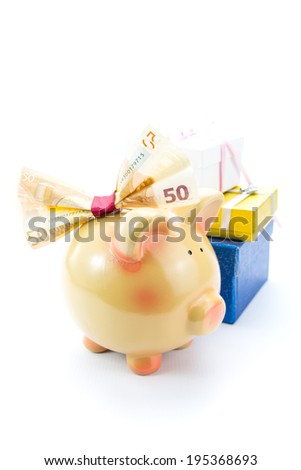 Piggy bank with a banknote bow and gift boxes