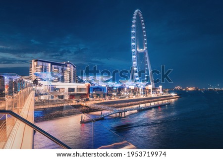 Night view from the pedestrian bridge on Blue waters Island with decorative lighting and one of the largest ferris wheels in the world - Dubai Eye Royalty-Free Stock Photo #1953719974