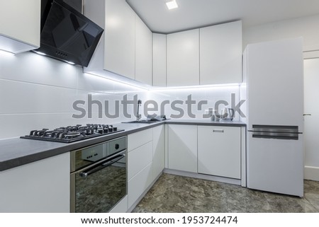Interior photo, modern kitchen, in light white tones, with black marble tiles on the floor, placed in a small apartment
