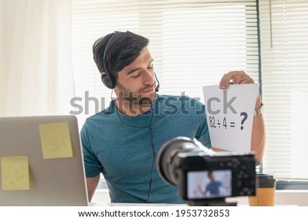 Smart young caucasian business man student, teacher tutor wear headset, look at camera,talk greeting on record video shooting. Technology learn teach in online chat, distance in education concept.
