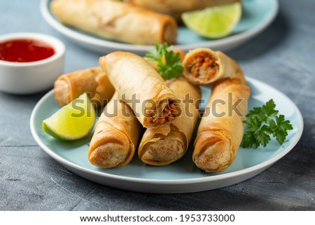 Fried spring rolls with sweet chili sauce and lime on plate Royalty-Free Stock Photo #1953733000