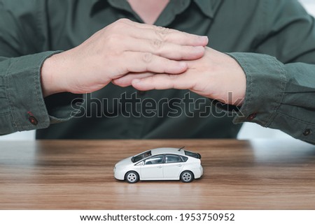 Toy car perfect condition on table and hand a man protection : Car safety concept 