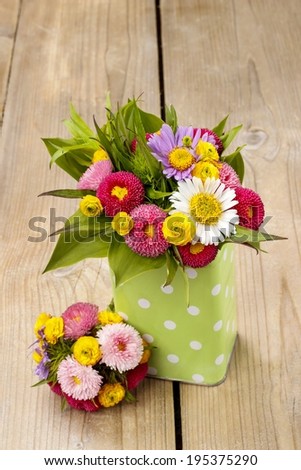 Bouquet of colorful wild flowers in green dotted can