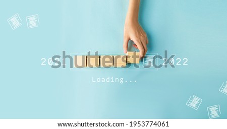 Hand of woman putting wood cube countdown to 2022. Loading year 2021 to 2022. Royalty-Free Stock Photo #1953774061
