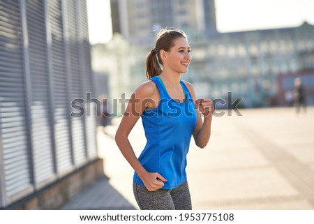 Happy pretty woman jogging in the city alone