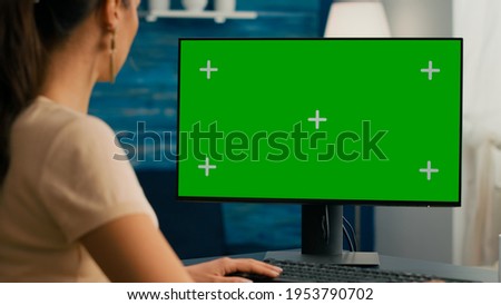 Close up of business woman use personal computer with mock up green screen chroma key. Freelancer sitting on chair at office desk working at financial graphs using isolated pc