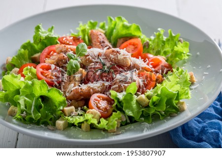 Caesar salad with chicken, cherry tomatoes and parmesan cheese. Greek cuisine.