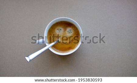 front top photography of a cup with a smiley face in coffee, large format 