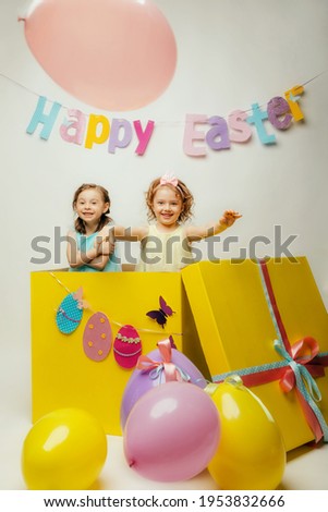 two cheerful children with balloons in the form of eggs colorful composition for easter