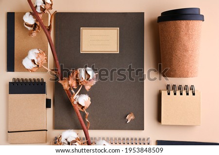 branding mockup with many craft paper and different subjects, glass for coffee. Office desk with a paper notepad and a box of pencils. Contemporary workspace for men, minimalist style. Mockup. 