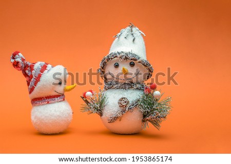 Christmas card, Happy New Year greetings. Snowman on an orange background, place for text. Christmas or New Years concept. Copy space.
