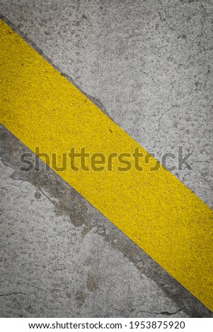 Light grey asphalt with yellow line as a street marks, space for text, vertical format
