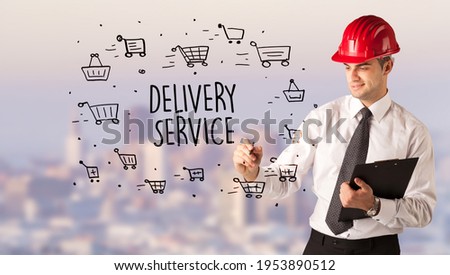 Young businessman with helmet drawing sale sign