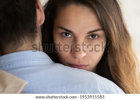 Close up portrait of young Latino woman hug husband feel unsure doubtful about relationships. Millennial female embrace man lover look at camera thinking. Cheating, relation problem concept. Royalty-Free Stock Photo #1953915583