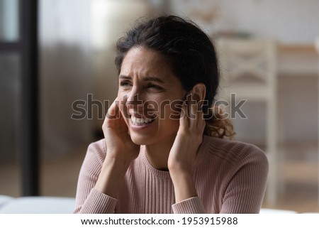 Be quiet. Annoyed nervous latina woman suffer of loud noise at home stick fingers in ears with grimace on face. Stressed young hispanic lady get tinnitus listen to rumbling music from neighboring flat Royalty-Free Stock Photo #1953915988