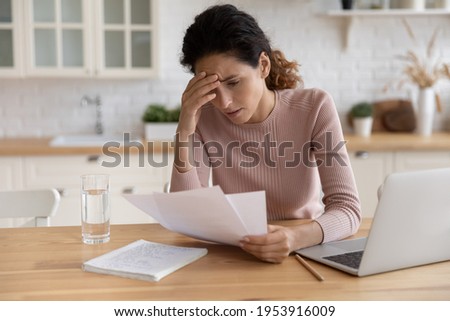 Worried stressed millennial female freelancer scratch forehead think on bank notification about business bankruptcy tax loan mortgage debt. Unhappy latin woman concern about bad news in paper letter Royalty-Free Stock Photo #1953916009