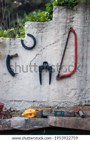 Amateur Still Life with Agricultural Artifacts and Tools on Fence Wall