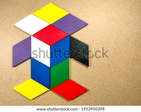 Color wood puzzle in unique robot shape on wood background with copy space.