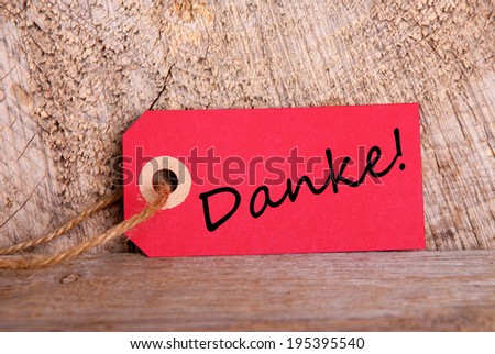 A Red Tag on Wood with the German Word Danke which means Thanks