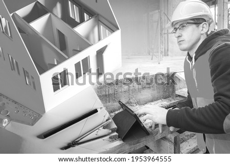 Builder in a building under construction. Layout of finished house. Concept work a team leader at a construction site. Builder is looking for something in the tablet. Search for drawings on Internet