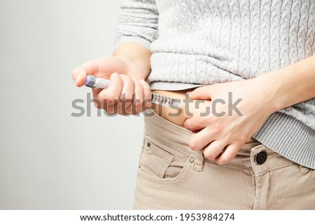Young woman doing insulin injection pen, close-up. Diabetic patient with insulin pen for control diabetes. Royalty-Free Stock Photo #1953984274