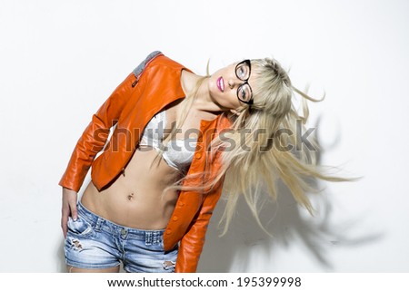 Fashionable blonde in bright clothes on a light background