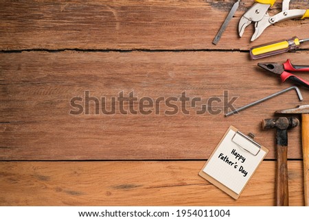 Happy Fathers Day text with side border of tools and ties on a rustic wood background