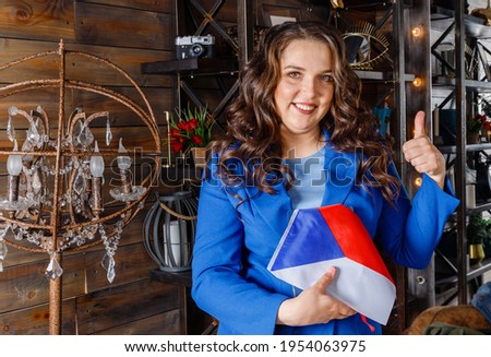 A woman holds the flag of Czech and showing thumb up. Beautiful female student with Czech flag. Czech study or student exchange program concept. education in Czech. Positive plump woman Royalty-Free Stock Photo #1954063975