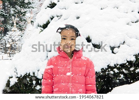 Happy girl plays with a snow in sunny winter day

