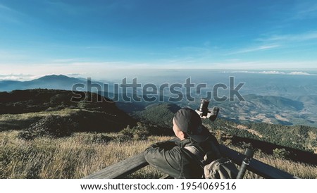  Asian hipster men backpacker enjoying take a photo on beautiful landscape background scenery view jungle mountains green forest at Doi Inthanon National Park, Chiang Mai, Thailand.