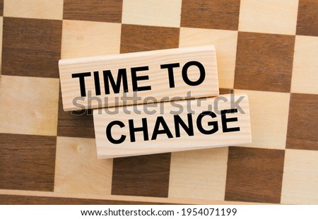 Chessboard with wooden blocks with text Time To Change. Concept photo