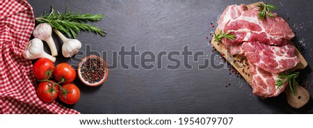 fresh pork meat with rosemary and ingredients for cooking, top view Royalty-Free Stock Photo #1954079707