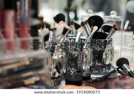 Close-up picture of workplace with make-up tools on table in beauty salon. Professional lipsticks and brushes for work of make-up artist. Work process in beauty studio.