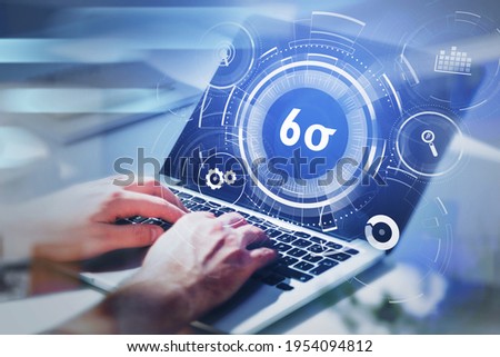 Businessman working on laptop and researching six sigma, quality control and manufacturing process management concept in business. virtual interface with cogwheels. Royalty-Free Stock Photo #1954094812