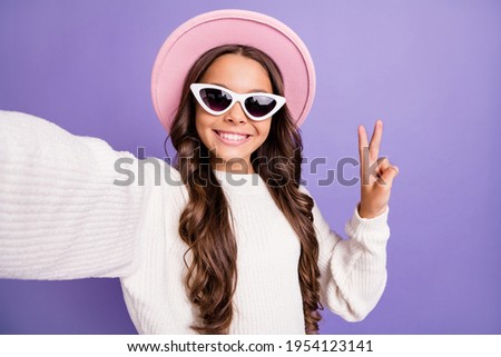 Photo of young school girl happy smile make selfie show hello greetings peace cool v-sign isolated over violet color background