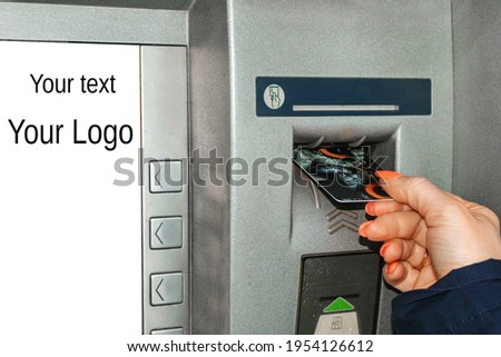 Girl's hand with a bank card at an ATM, with a white screen for text in a close-up