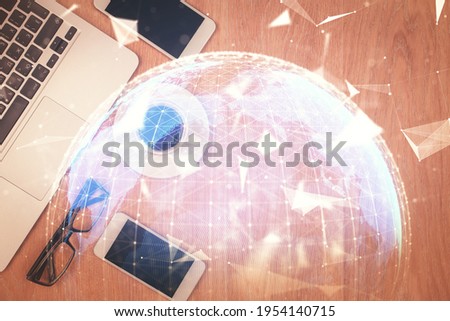 Double exposure of business theme hologram over desktop with phone. Top view. Mobile international trade connection concept.
