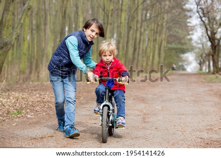 Little boy, learning how to ride a bike in the park, springtime