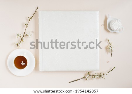 White family or wedding photo album with apple flowers and cup of tea and marshmallow