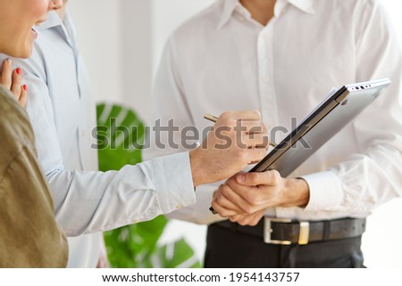 Confident caucasian real estate agent with House model on document, sign contract