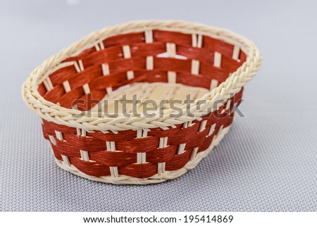Red wicker basket on gray background.