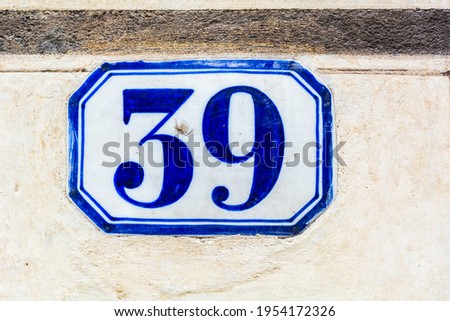 house number thirty nine ( 39 ) on a roughcast wall