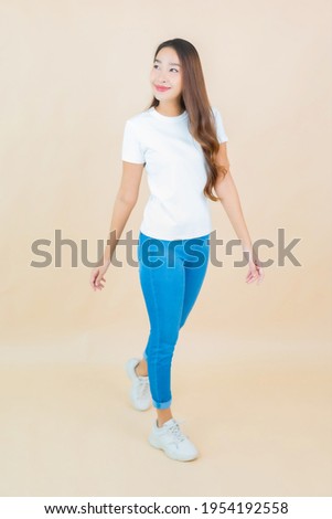 Portrait beautiful young asian woman smile with action with cream color background