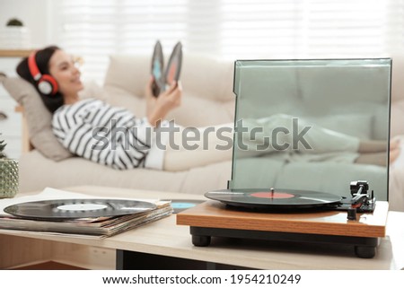 Woman listening to music with turntable in living room
