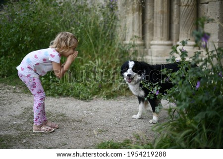 A little girl is whispering to a friendly dog